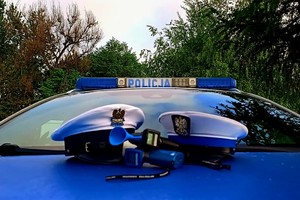 Na zdjęciu czapki policjantów ruchu drogowego oraz alkomaty lezące na przedniej masce radiowozu