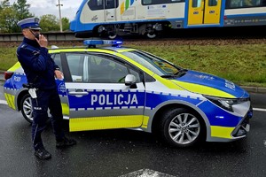 Na zdjęciu policjant przy radiowozie