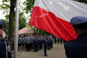Na zdjęciu flaga Polski i policjanci