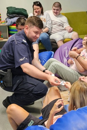 NA zdjęciu policjant z podopiecznymi