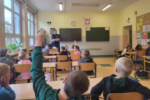 Na zdjęciu policjant i pierwszoklasiści