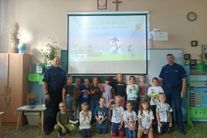 Na zdjęciu policjant i pierwszoklasiści