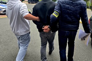 Na zdjęciu zatrzymany wraz z policjantami