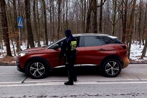 Na zdjęciu policjant przeprowadzający kontrolę trzeźwości