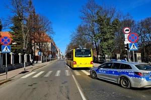 policyjny radiowóz przed przejściem dla pieszych oraz autobus miejski
