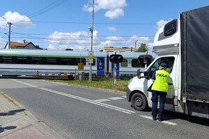 policjantka podczas kontroli pojazdu przy przejeździe