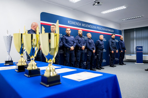 puchary na tle uczestników konkursu